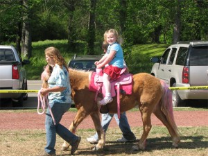 I finally get a smile out of Taylor as she\'s riding the pink pony